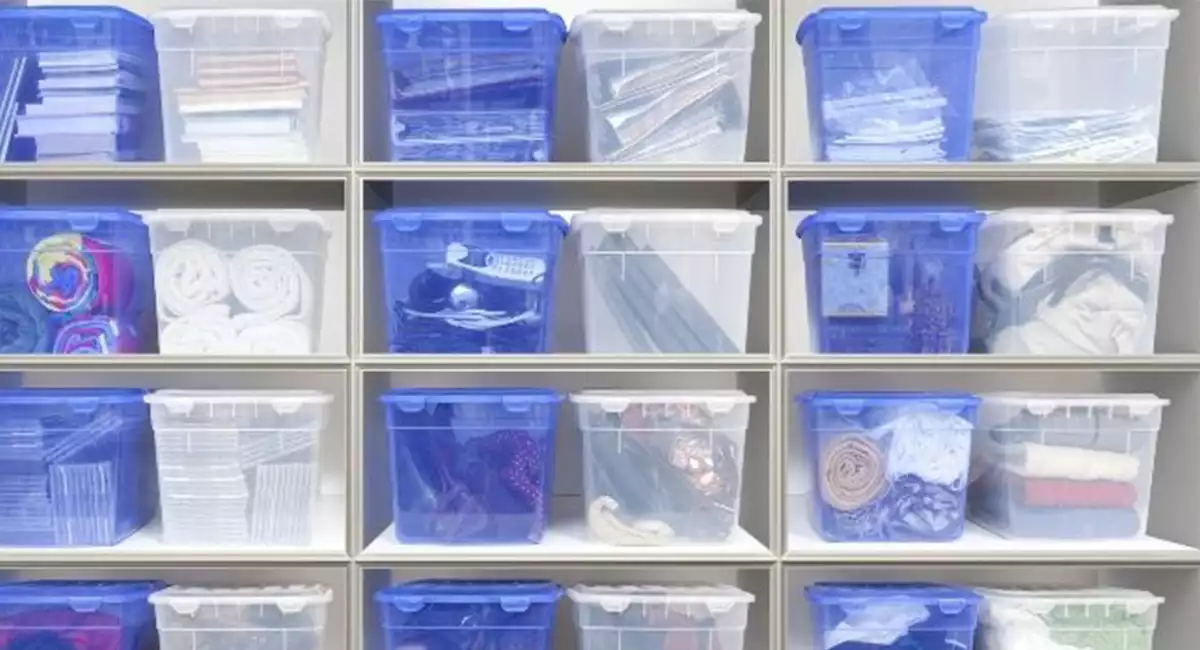 Nicely organized blue and clear colored storage bins on shelving unit.