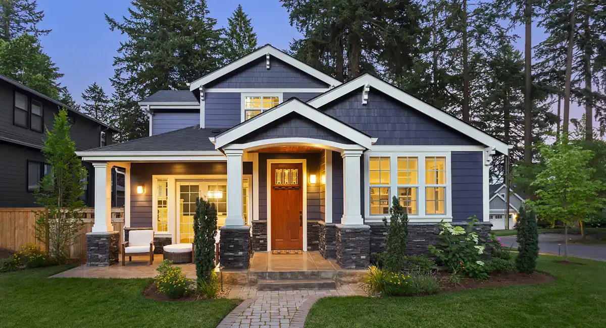 Blue, white, and grey home with beautiful clean landscaped front yard.