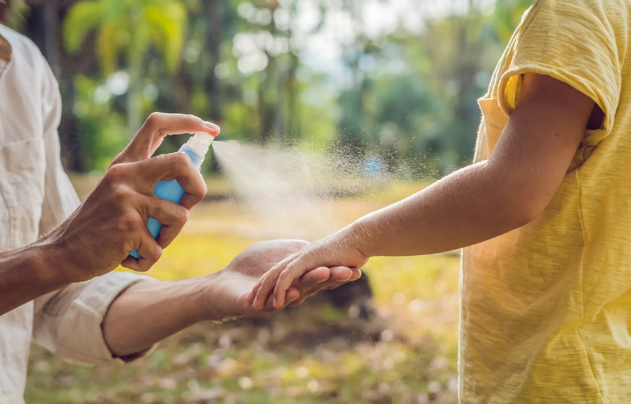mom sprays her sons with bug spray