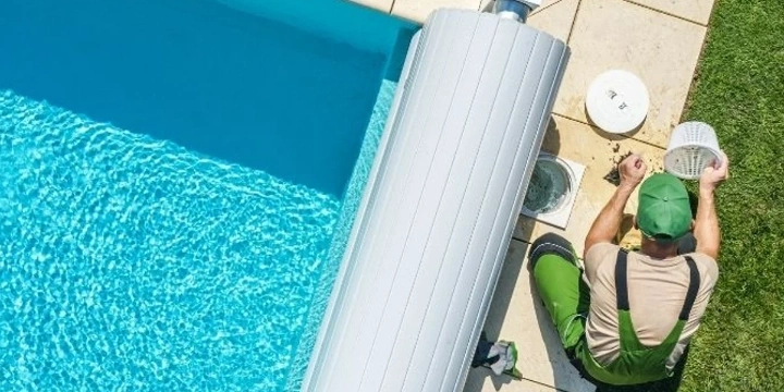Professional Garden Technician working on pool cover and pool filter.