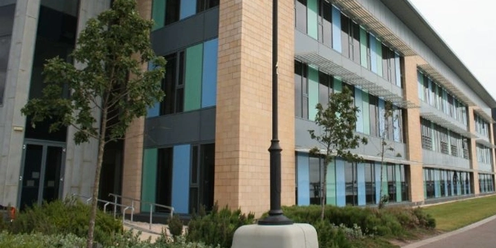 Low rise commercial office building with multi-colored windows and landscaping