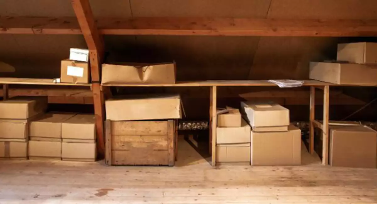 Stacks of boxes inside a wooden attic.