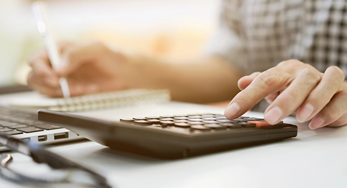man calculates costs with calculator and notebook