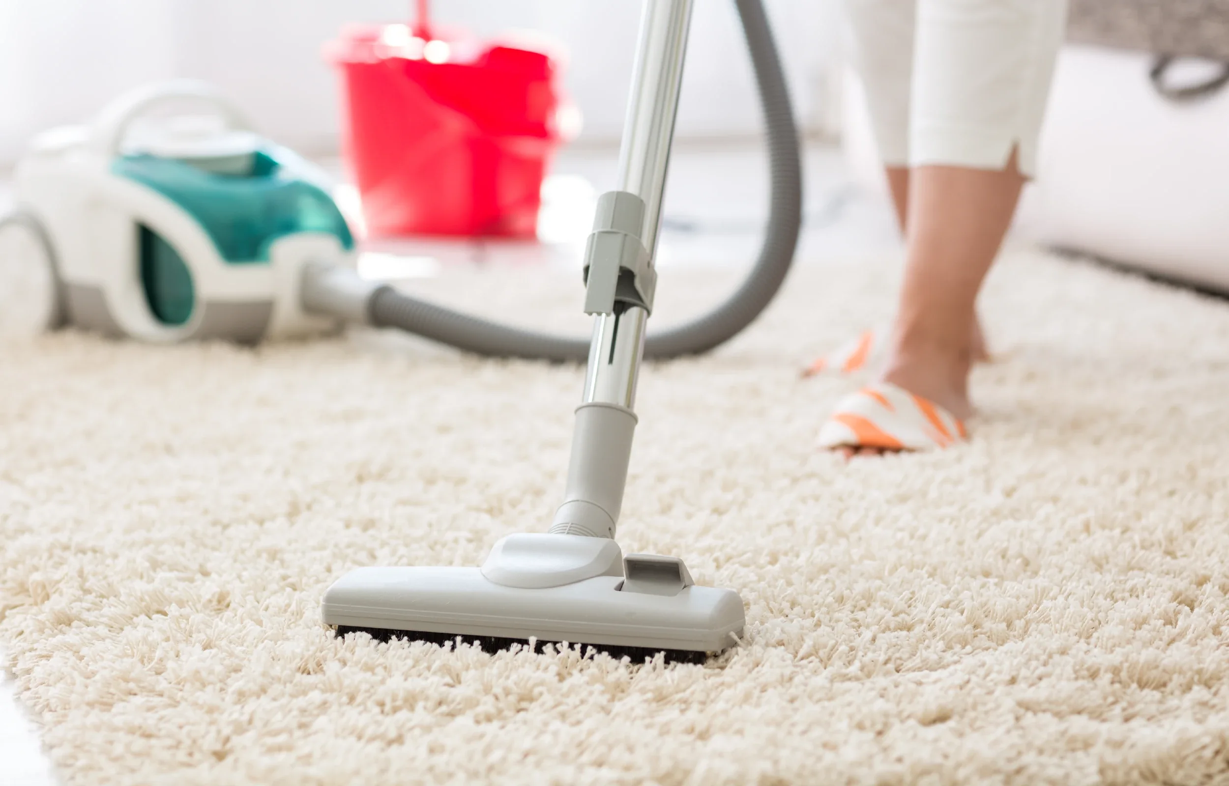 Woman using vacuum cleaner to clean floor in living room